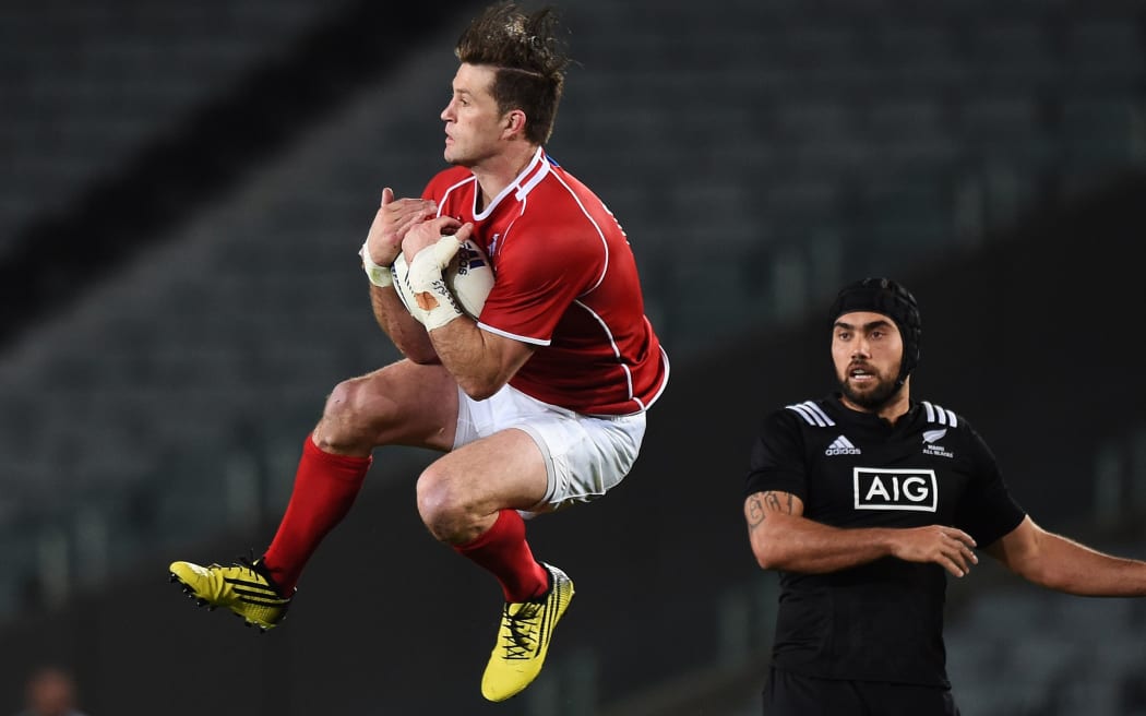 The Maori All Blacks captain Charlie Ngatai looks on as Cory Jane secures the high ball.