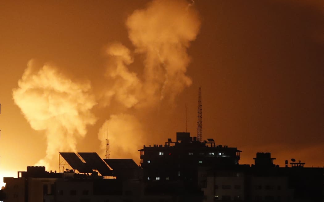 Smoke rises above buildings in Gaza City as Israel launches air strikes on the Palestinian enclave on late April 6, 2023. - Several explosions coming from Gaza were heard by AFP journalists on April 6, 2023, night, as the Israeli army said it was carrying out strikes in the area. The Israeli army "is currently striking in the Gaza Strip," read an army statement shortly after AFP heard at least three explosions. A Palestinian security source said the strikes had hit several Hamas training sites. (Photo by MOHAMMED ABED / AFP)