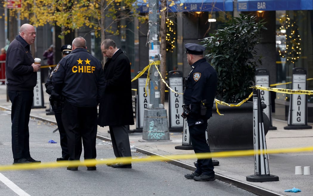 Police officers stand near the scene where the CEO of United Healthcare Brian Thompson was shot and killed in New York City on December 4, 2024.
