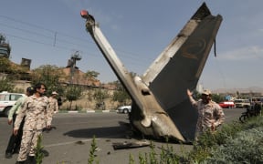 Members of the Iran Revolutionary Guards next to the remains of the plane.