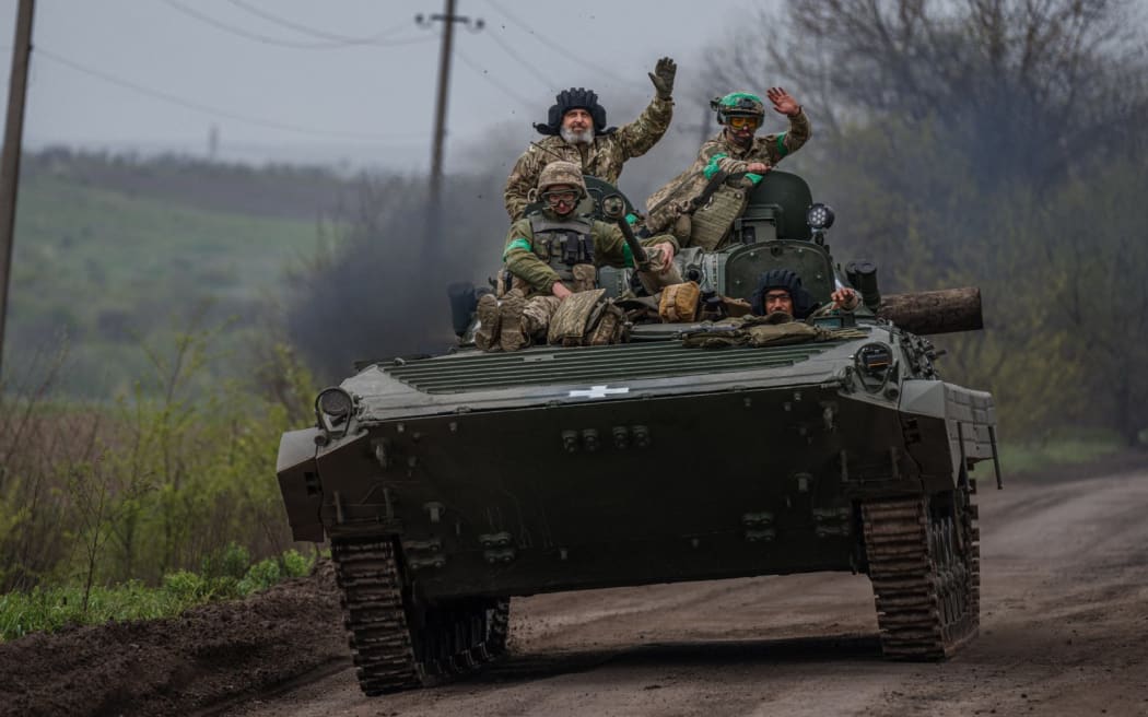 Ukrainian servicemen ride in a BMP infantry fighting vehicle near the town of Bakhmut, in the Donetsk region, on April 28, 2023, amid the Russian invasion on Ukraine. (Photo by Dimitar DILKOFF / AFP)