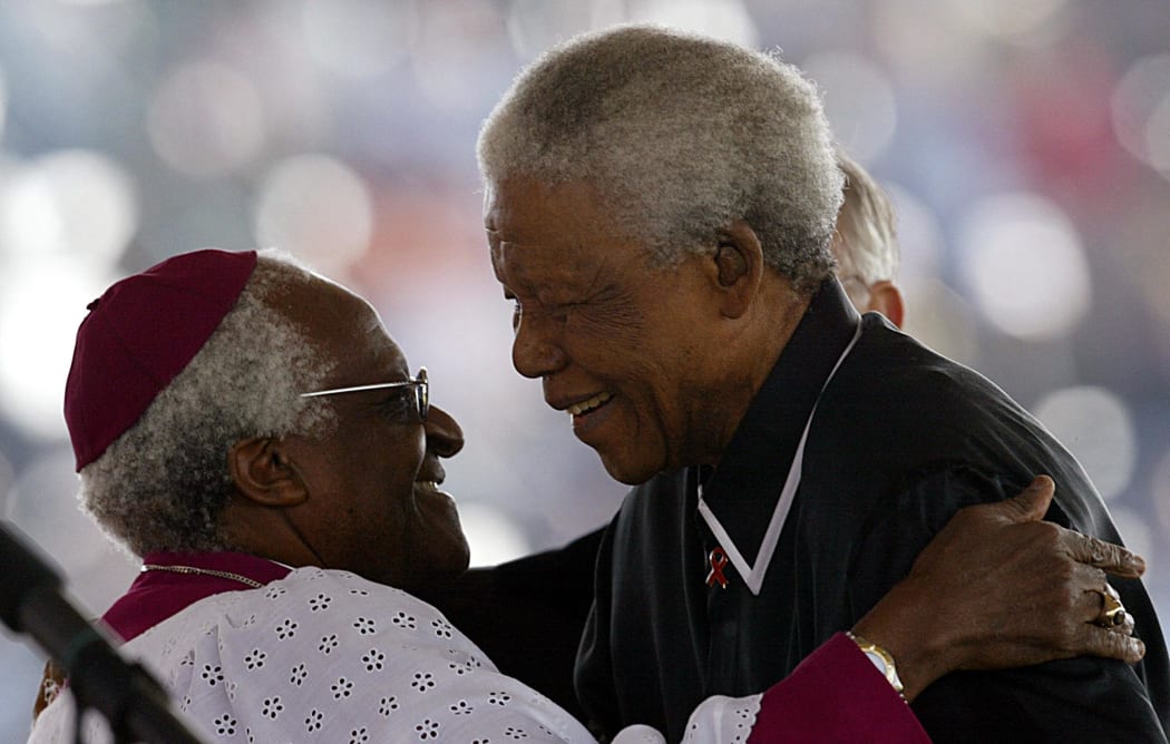 Nelson Mandela and Desmond Tutu embrace in 2003 as they pay tribute to their late friend Walter Sisulu, at the apartheid struggle hero's state funeral