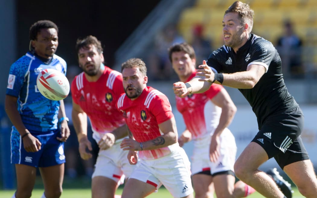 French players look on as Tim Mikkelson throws a pass.
