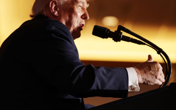 MOUNT POCONO, PENNSYLVANIA - DECEMBER 09: U.S. President Donald Trump sports a bandage on his right hand as he delivers remarks during an event at Mount Airy Casino Resort on December 9, 2025 in Mount Pocono, Pennsylvania. Trump discussed his administration's economic agenda and its efforts to lower the cost of living.   Alex Wong/Getty Images/AFP (Photo by ALEX WONG / GETTY IMAGES NORTH AMERICA / Getty Images via AFP)