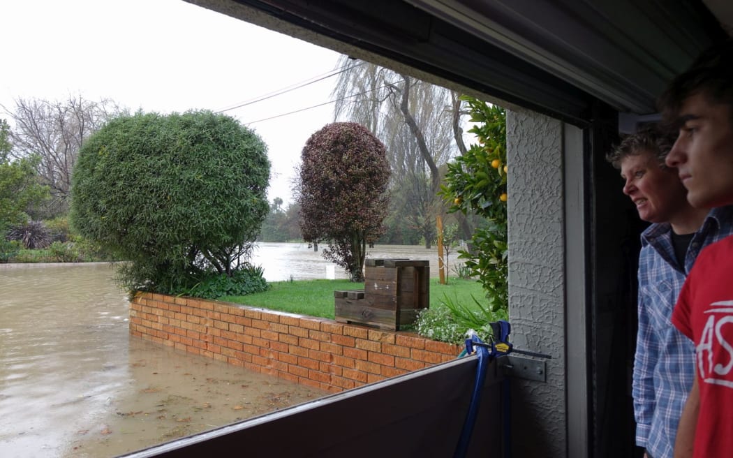 Joanne Bos and visiting student Peio Tamara watch the rising flood waters at their Howe Street home.