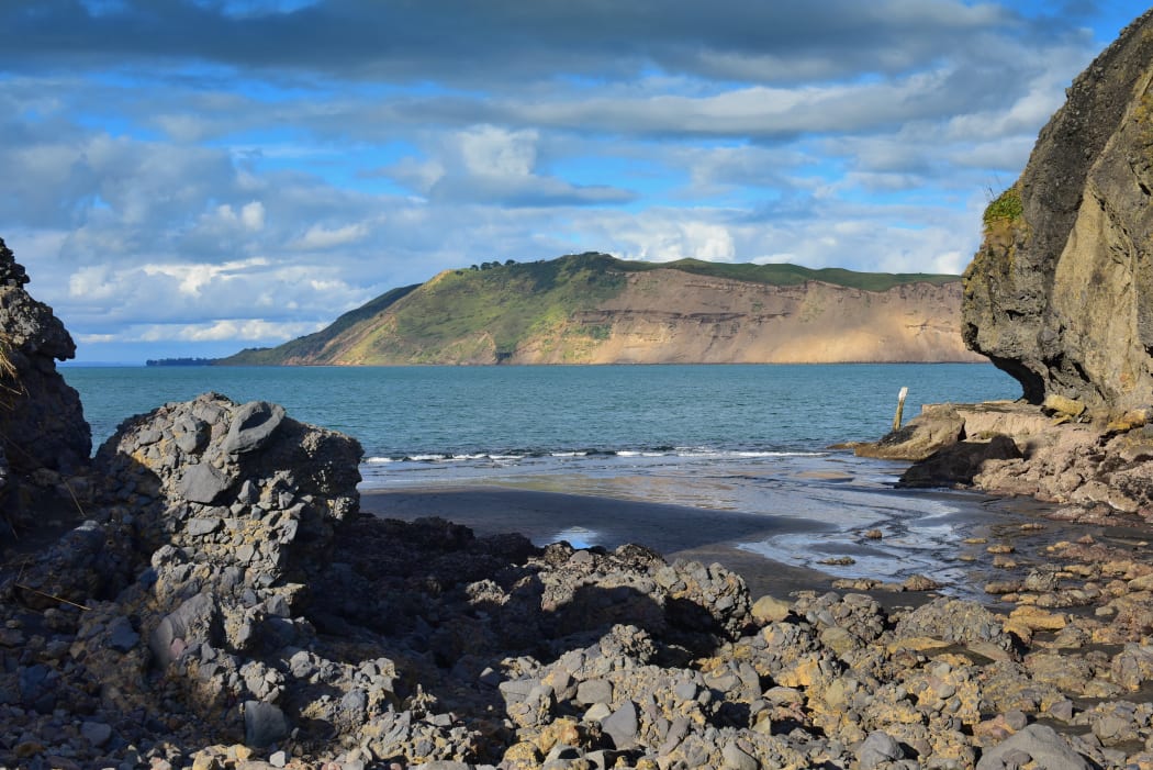 Cliffs and rock formations along black sand Whatipu Beach in Huia, West Auckland in New Zealand