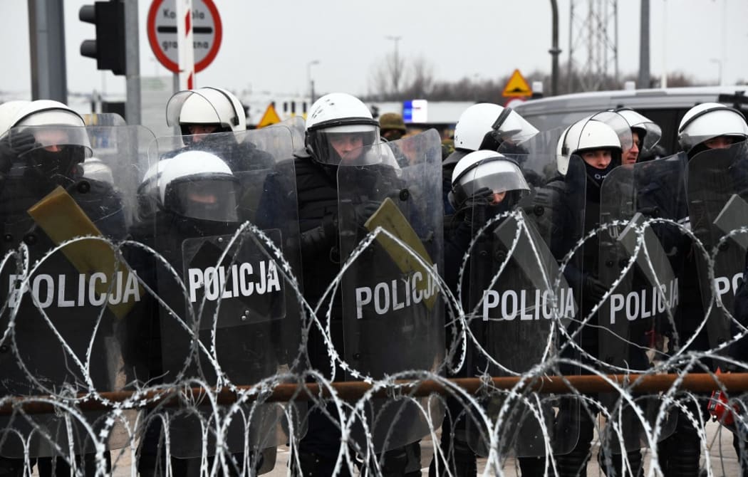 6696043 15.11.2021 Polish police officers stand guard behind a fence at the Bruzgi-Kuznica Bialostocka border crossing near the Belarusian-Polish border, Belarus.