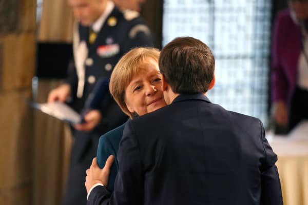 22 January 2019, North Rhine-Westphalia, Aachen: Emmanuel Macron (r), President of France, gives a cheek kiss to German Chancellor Angela Merkel (CDU) during the signing ceremony of the new Franco-German friendship treaty in the coronation hall of the town hall.