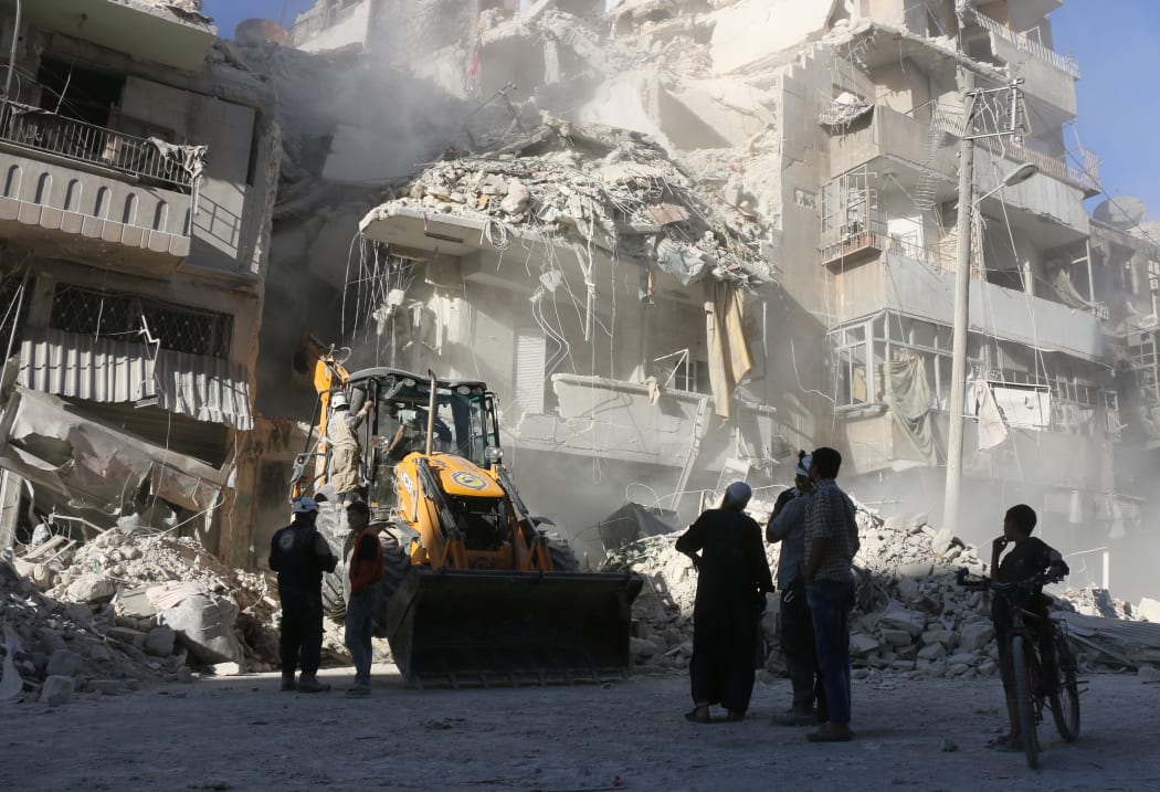 A tractor clears rubble away in Aleppo as relentless airstrikes on the city continue.