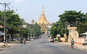 This screengrab provided via AFPTV taken on March 24, 2021 shows an empty street next to Shwedagon Pagoda in Yangon, as demonstrators called for a "silent strike" in protest against the military coup. (Photo by AFPTV / AFP)