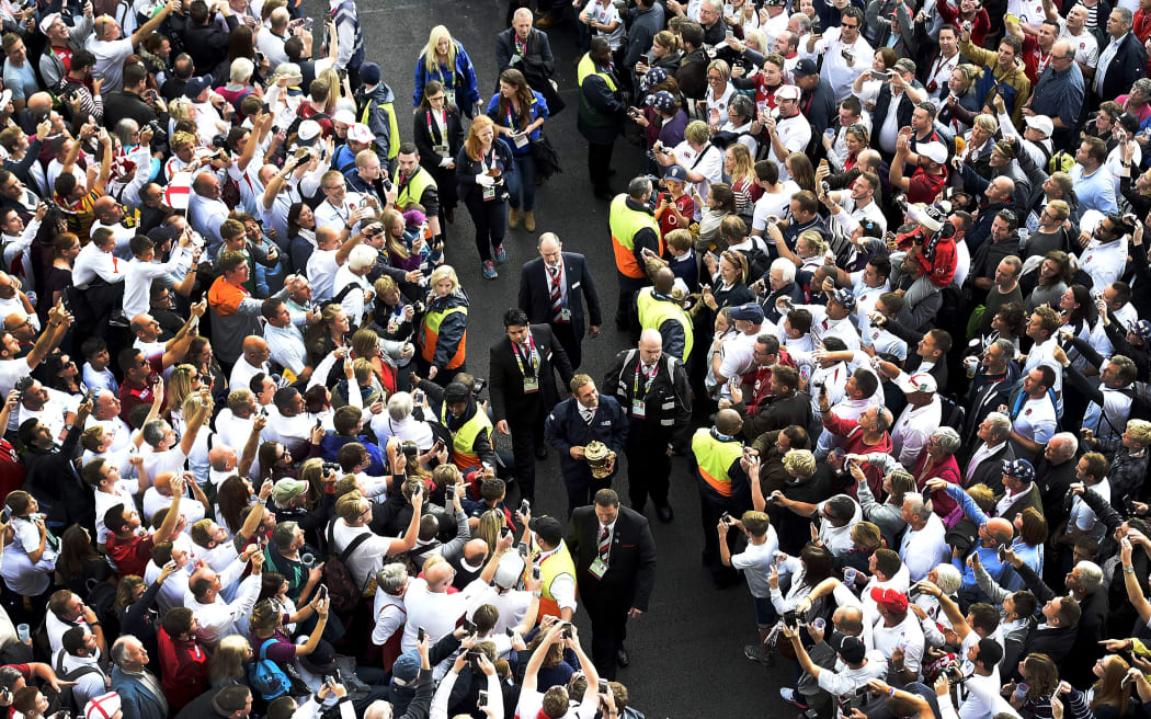 Former England rugby international Jonny Wilkinson carries the Webb Ellis Cup between crowds prior to the opening ceremony.