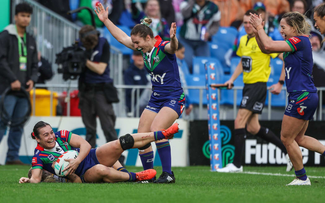 Tysha Ikenasio of the Warriors scores a try as Michaela Brake of the Warriors and Apii Nicholls (captain) of the Warriors cheer,,