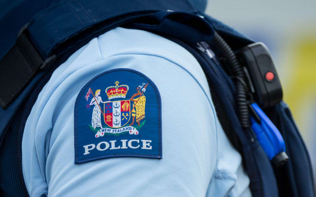 Close up of a police officer at an incident on a residential street. 6 July 2016.