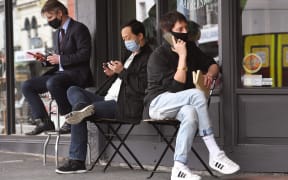 Men queue for a haircut outside a barber shop in Melbourne on October 19, 2020, as some of the city's three-month-old stay-at-home restrictions due to the COVID-19 coronavirus outbreak were further eased on falling infection rates.