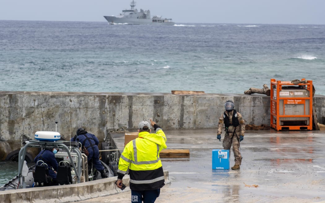 Tokelau national GM Aukusitino Vitale, gives the thumbs up to an HMNZS Wellington officer unloading Pfizer vaccines