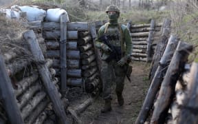 A Ukrainian serviceman patrols along a trench in Schastya, Lugansk region, near the frontline with Russia-backed separatists yesterday.