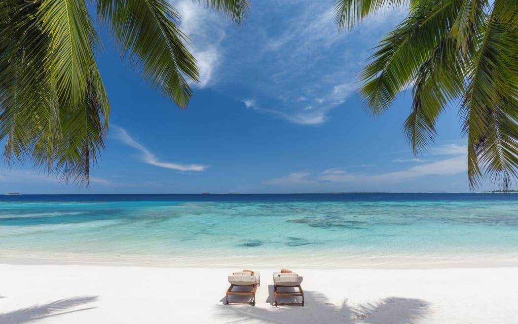 Wooden lounge chairs on a beautiful tropical beach, The Maldives, Indian Ocean, Asia (Photo by Sakis Papadopoulos / Robert Harding RF / robertharding via AFP)