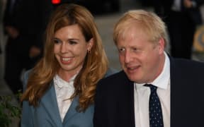 Britain's Prime Minister Boris Johnson walks with his partner Carrie Symonds as they arrive at The Midland, near the Manchester Central convention complex in Manchester, northwest England on September 28, 2019,