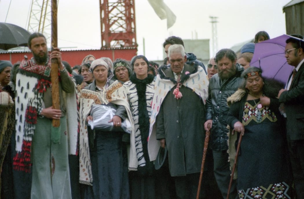 Maori Land March at Parliament Grounds, Wellington 13th October 1975. Cyril Chapman is holding pouwhenua; Titewhai Harawira wearing black and white coat.
Photograph by Christian Heinegg.
ATL Ref: 35mm-87566-24-F
