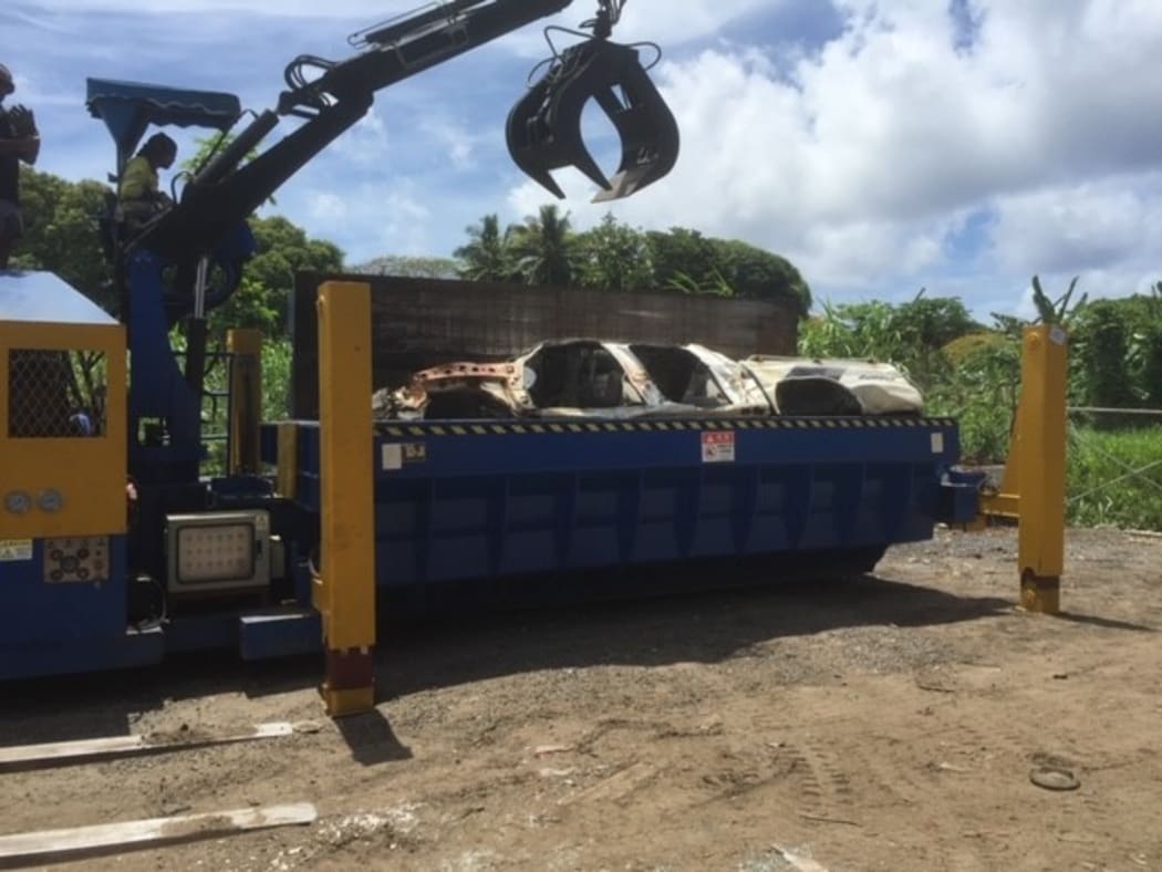 A the vehicle whole state then baled state, then being hoisted out of the baler for stacking inside container for shipping.