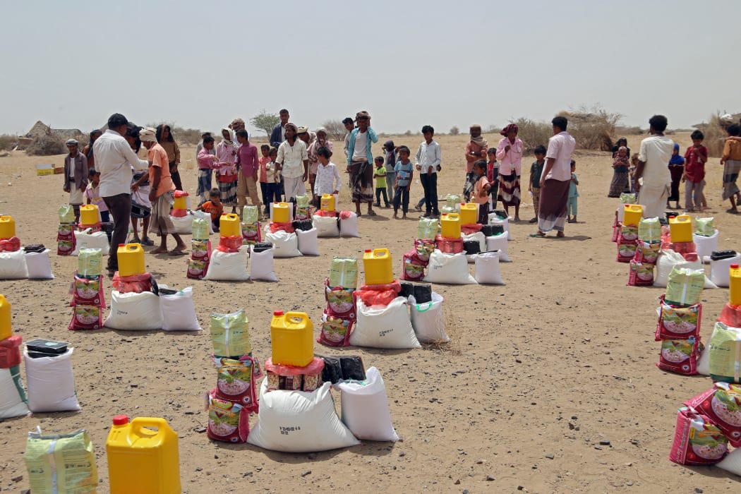 Yemenis displaced by the conflict, receive food aid and supplies to meet their basic needs, at a camp in Hays district in the war-ravaged western province of Hodeida on March 29, 2022.
