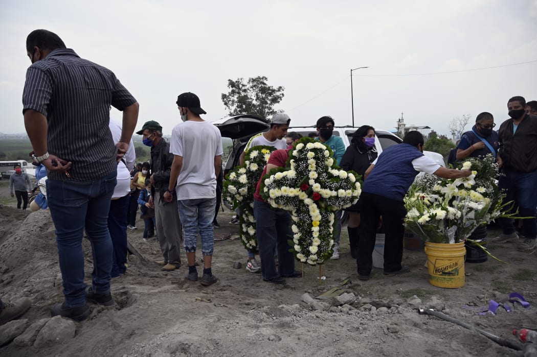 Relatives attend the funeral of a suspected Covid-19 victim in Valle de Chalco state, Mexico on 15 August.