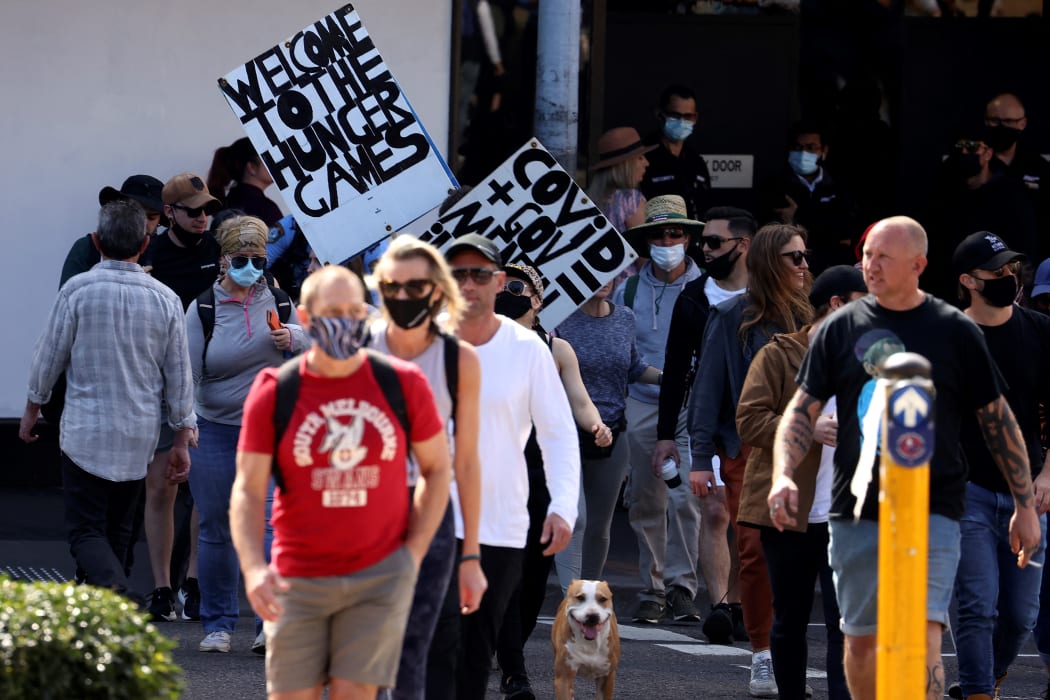 Protestors those with placards gather in Sydney on August 21, 2021, following calls for an anti-lockdown protest rally amid a fast-spreading coronavirus outbreak.