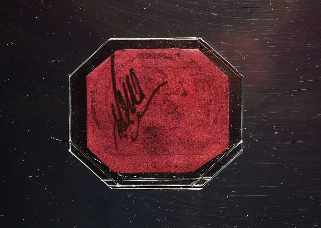 The front of the British Guiana One-Cent Magenta, described as the most famous stamp in the world, on display in a glass case at Sotheby's New York.
