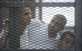 Peter Greste (left) Mohamed Fahmy and Baher Mohamed listen to the verdict.