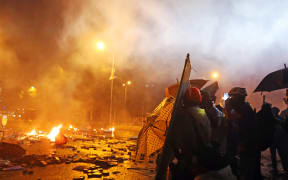 Protesters are thrown tear bombs by police officers on the street near Hong Kong Polytechnic University in Hong Kong on November 17, 2019.