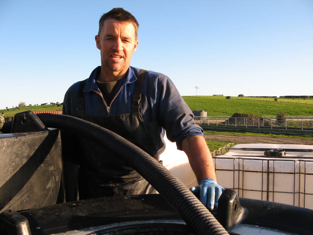 Andrew McPherson beside his colostrum tanks.