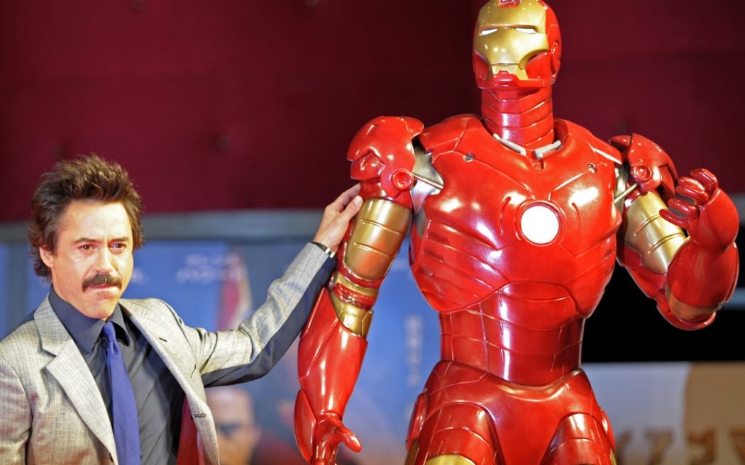 US actor Robert Downey Jr. poses by a life-size Iron Man model during a press conference on his latest movie Iron Man, in Tokyo, on September 3, 2008. The movie will roadshow in Japan from September 27.   AFP PHOTO / TOSHIFUMI KITAMURA