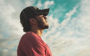 guy in cap looking at the sky