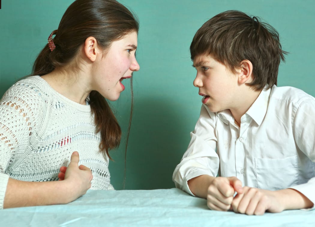 teen siblings boy and girl arguin close up photo