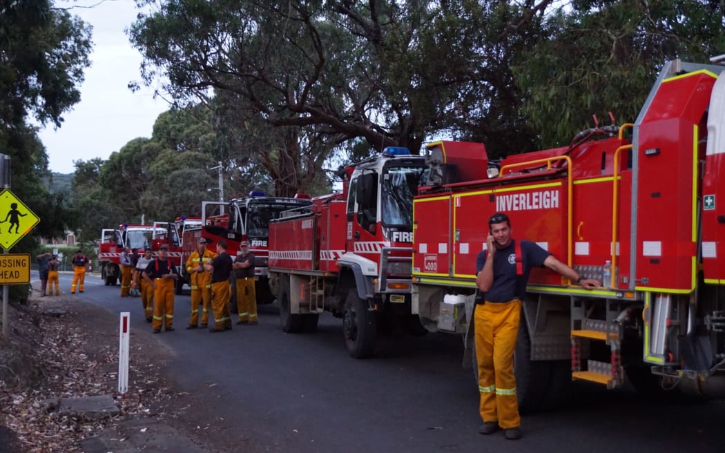 Country Fire Authority volunteer fire-fighters take a break while fighting fires which flared in a scenic area along Victoria's Great Ocean Road on Christmas Day, destroying dozens of houses.