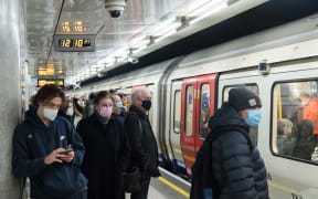 Commuters wearing face masks travel on the London Underground.