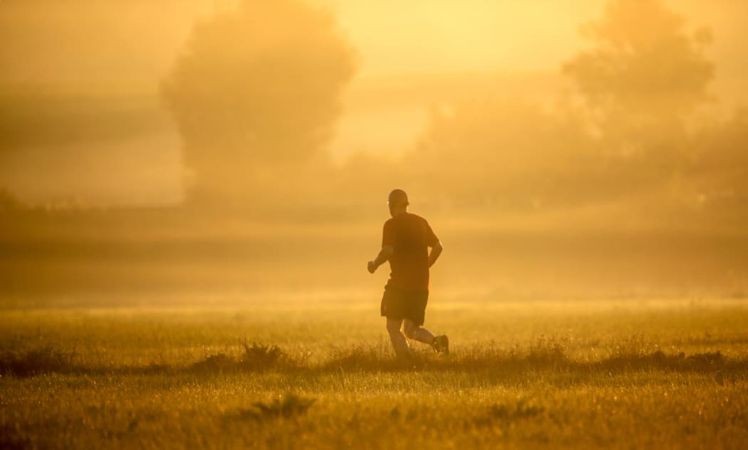 24 July 2019, Baden-Wuerttemberg, Unlingen: A jogger runs towards the sun shortly after sunrise. Temperatures of up to 38 degrees are predicted for the course of the day. Photo: Thomas Warnack/dpa (Photo by Thomas Warnack / DPA / dpa Picture-Alliance via AFP)