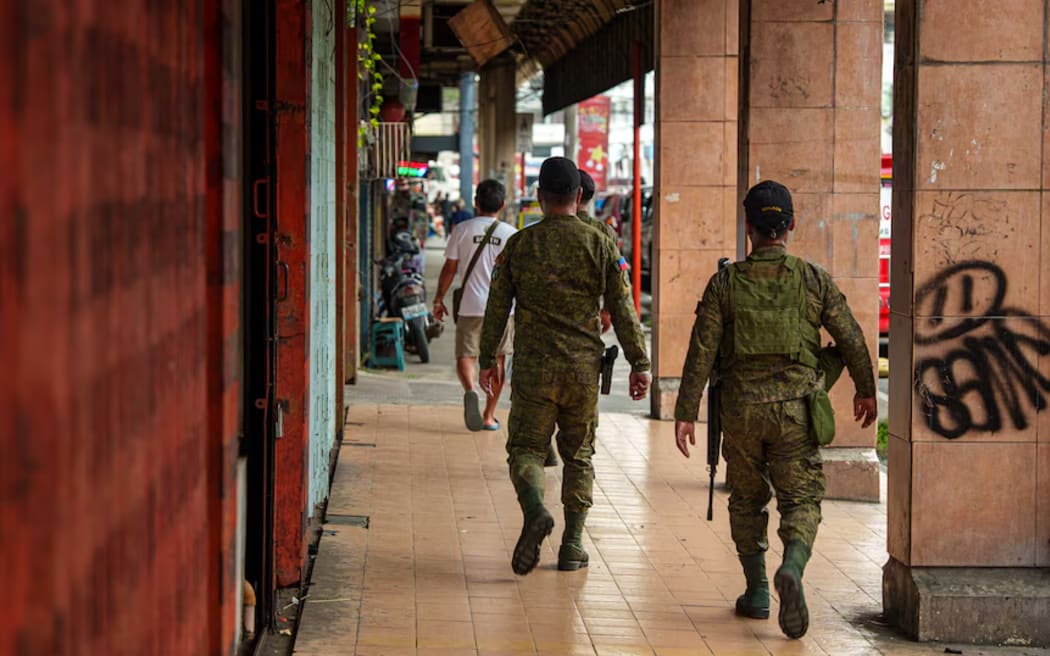 Military personnel passing near the GV Hotel.