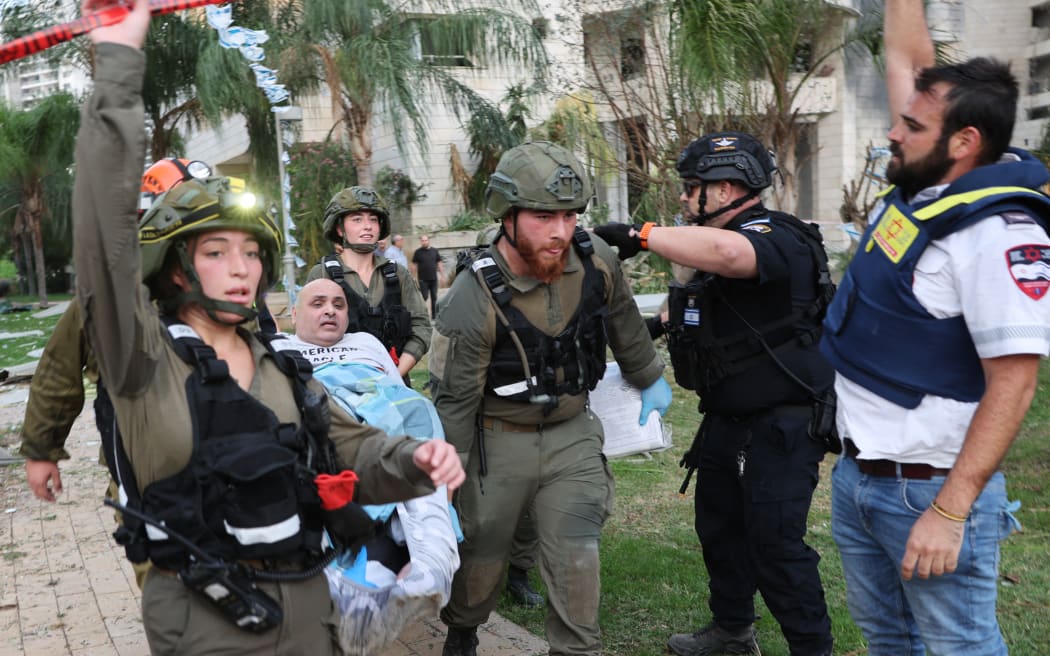 Responders evacuate a man from a damaged building following a strike by an Iranian missile in the Israeli city of Petah Tikva, east of Tel Aviv, on June 16, 2025. Israel's military warned on June 16 of a new missile salvo incoming from Iran, as AFP journalists reported loud explosions in Jerusalem and fires outside the coastal city of Haifa. "A short while ago, the IDF identified missiles launched from Iran toward the territory of the State of Israel," the army posted on Telegram, using the acronym for its official name. (Photo by Jack GUEZ / AFP)