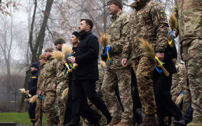 In this handout photograph taken and released by the Ukrainian Presidential Press Service on November 22, 2025, Ukraine's President Volodymyr Zelensky (C-R), his wife Olena Zelenska (C-L) and Ukrainian soldiers pay a tribute to the victims of the famine of 1932-1933 at the National Museum of the Holodomor-Genocide, in Kyiv. (Photo by Handout / UKRAINIAN PRESIDENTIAL PRESS SERVICE / AFP) / RESTRICTED TO EDITORIAL USE - MANDATORY CREDIT "AFP PHOTO / UKRAINIAN PRESIDENTIAL PRESS SERVICE" - NO MARKETING NO ADVERTISING CAMPAIGNS - DISTRIBUTED AS A SERVICE TO CLIENTS