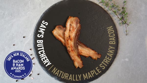 Naturally maple streaky bacon on a black plate.
