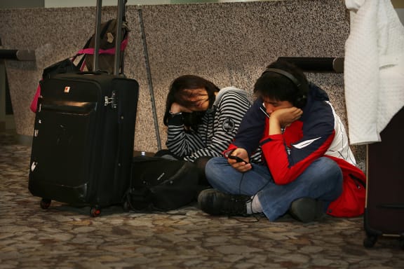 Brother and sister Thomas and Joyce Ishikawa wait at Wellington Airport.