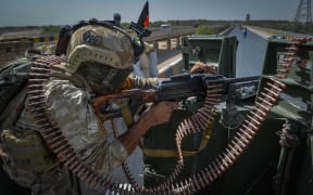 A security personnel stands guard on top of a vehicle outside United Nations Assistance Mission in Afghanistan (UNAMA) office compound in Guzara district of Herat province on 31 July, 2021.
