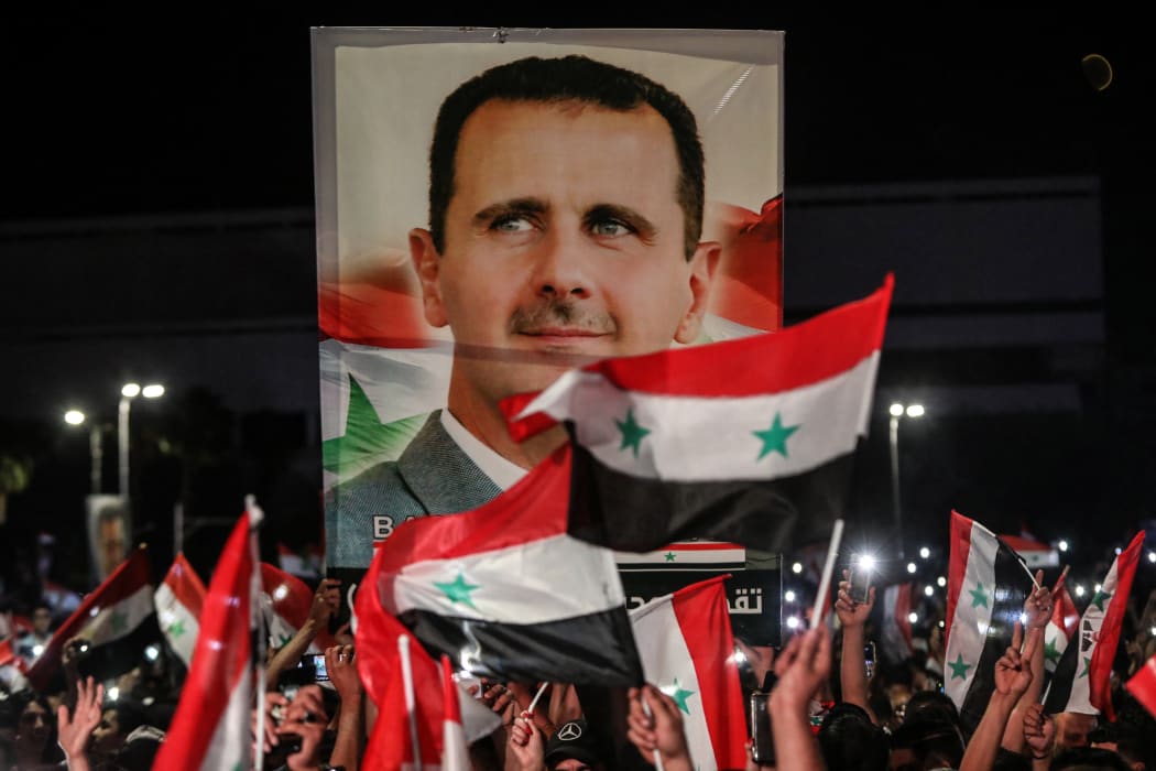 Syrians waved national flags and carried portraits of their president Bashar al-Assad in the capital Damascus yesterday, a day after the election.