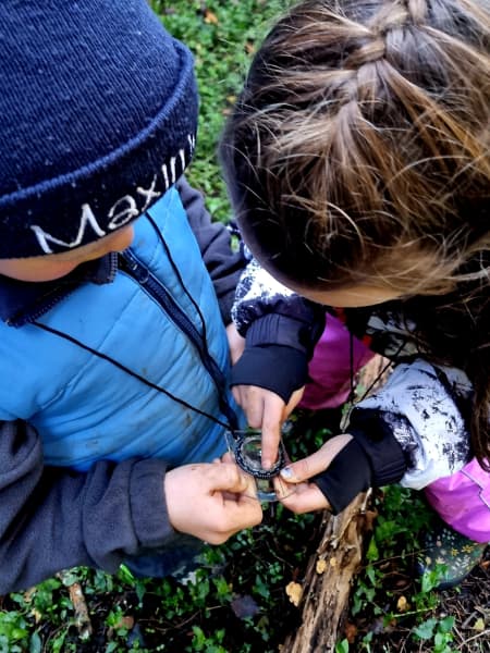 Child learning to use a compass outdoors.