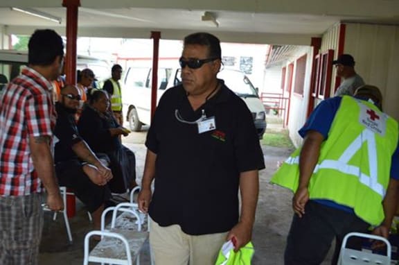 A Tongan Red Cross officer leads a mosquito cleanup operation to combat dengue fever.