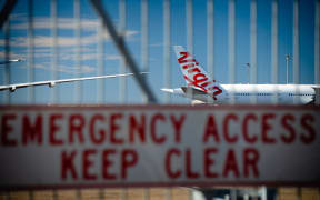 Virgin Australia aircraft are seen parked on the tarmac at Brisbane International airport on April 21, 2020.