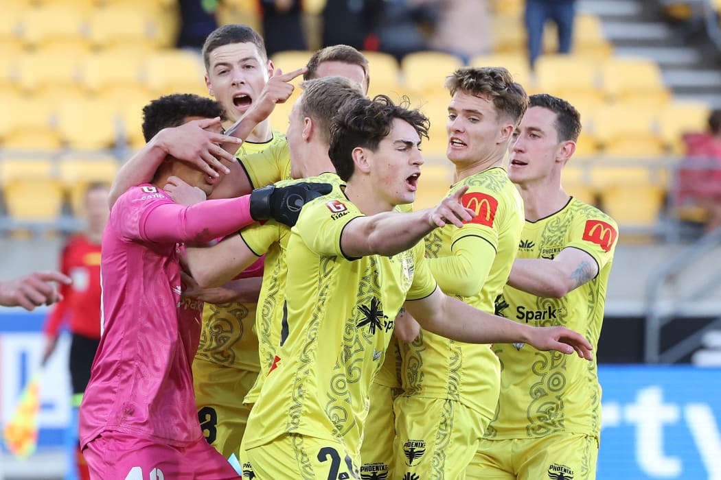 Wellington Phoenix players congratulate goalkeeper Alex Paulsen after his penalty save against Perth Glory.