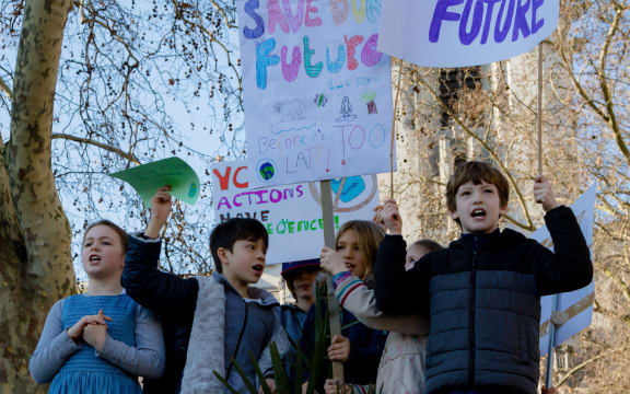 Striking school aged children in central London hold climate change holding placards.