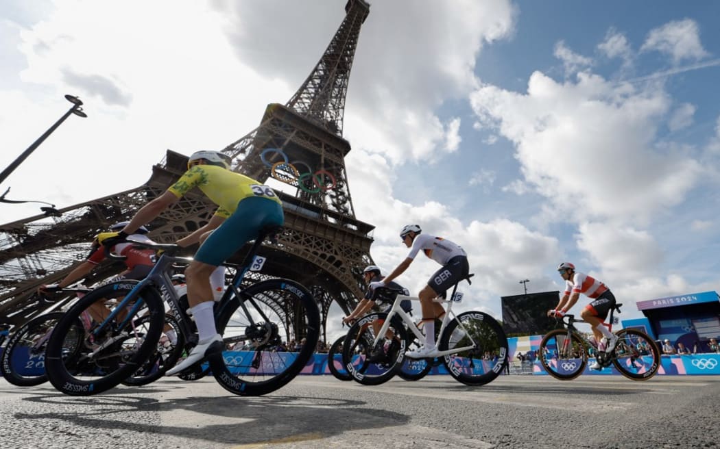 Germany's Nils Politt (C) cycles with the pack of riders (peloton) past the Eiffel Tower at the start of the men's cycling road race during the Paris 2024 Olympic Games in Paris, on August 3, 2024. (Photo by Odd ANDERSEN / AFP)